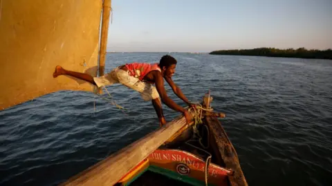 EPA A man adjusting the mast on a dhow boat in south eastern Kenya.