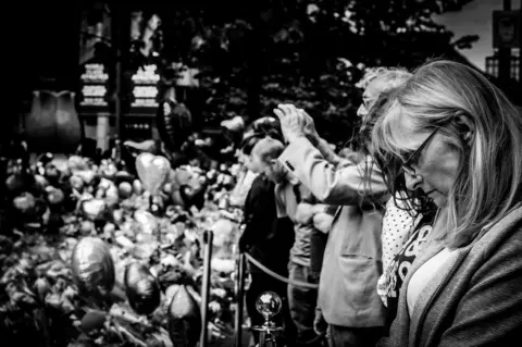 Leah Metcalfe People gather at St Anne's Square in Manchester