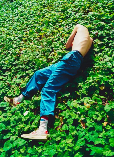 Sorren Harrison A boy lies amongst the plants