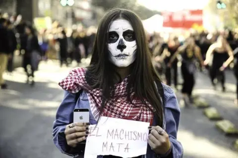 EPA A woman holds a sign that reads "machismo kills" during a demonstration in Santiago, Chile, 06 June 2018.