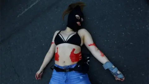 Reuters A demonstrator lies on the ground during a march demanding an end to sexism and gender violence in Santiago, Chile June 6, 2018