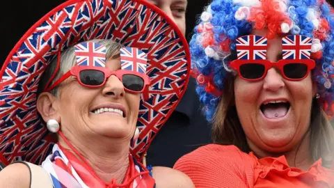 Pacemaker Women in Union flag colours watch the Twelfth parade in Belfast