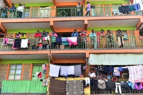 AFP People stand on their balconies and look out.