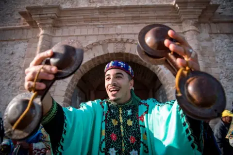 AFP A man sings as he plays steel hand-held cymbals, called krakebs.