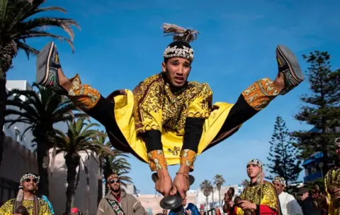 AFP A man jumps in the air as he plays steel hand-held cymbals, called krakebs.
