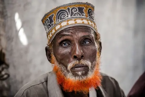 AFP An elderly man looks directly into the camera.