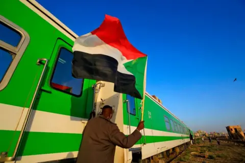 AFP Sudanese protesters wait at a train station in Khartoum to board a train to Atbara.