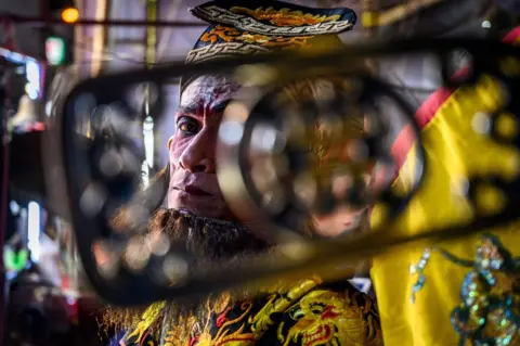 Mladen Antonov / AFP An actor rests during a Chinese opera performance