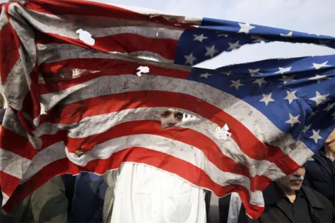 Abedin Taherkenareh / EPA A US flag is defaced during an anti-US demonstration