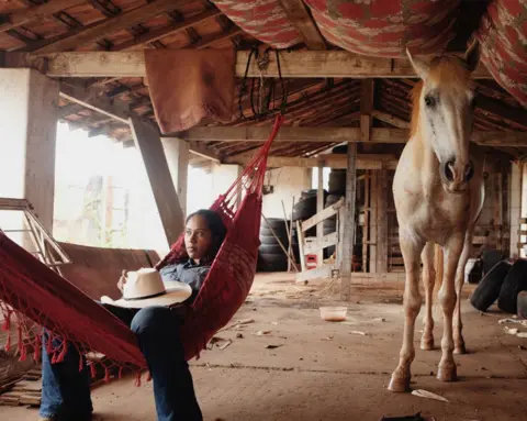 Luisa Dörr A woman lying in a hammock next to a horse