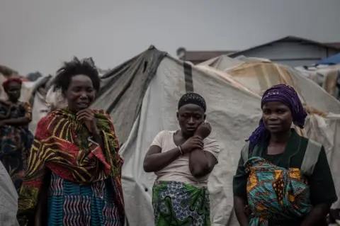 AFP Women discuss the state of the Nyiragongo volcano disaster at the Kayembe camp for displaced people, near Goma on August 30, 2021