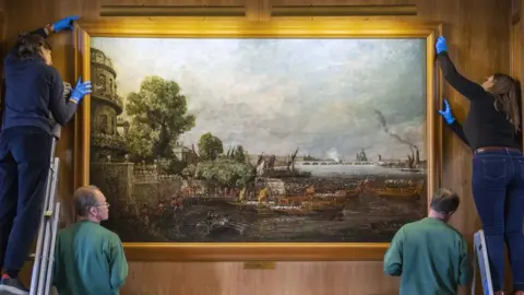 National Trust/James Dobson A painting, The Embarkation of George IV from Whitehall: the Opening of Waterloo Bridge, 1817, being hung at Anglesey Abbey in Cambridgeshire