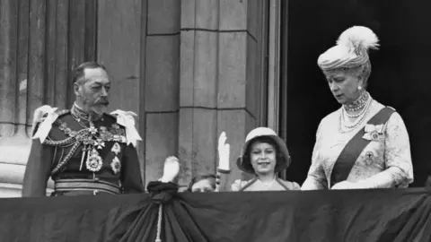 Getty Images The future Queen Elizabeth II waving from the balcony of Buckingham Palace in London, with her younger sister Margaret and her grandparents King George V and Queen Mary, on the occasion of their Silver Jubilee, 6th May 1935