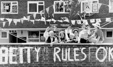 Getty Images A group of Fulham residents show their support for Queen Elizabeth II's twenty-fifth year of her reign by waving enthusiastically under strings of banners