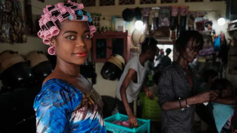 AFP A woman in curlers and make-up at a beauty salon in Bujumbura, Burundi - Monday 2 May 2022