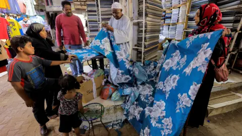 Reuters A family looking at material in a shop in Khartoum, Sudan - Friday 29 April 2022