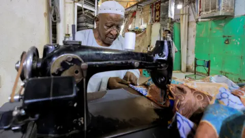 Reuters A tailor working at a sewing machine in Khartoum, Sudan - Friday 29 April 2022