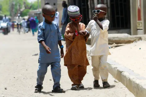 Reuters Three boys in Eid outfits and sunglasses in Maiduguri, Nigeria - Monday 2 May 2022