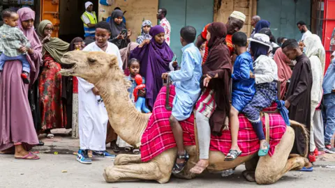 Getty Images Children sitting on a seated camel in Nairobi, Kenya - Monday 2 May 2022
