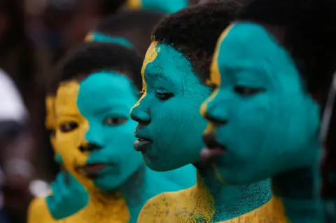 Reuters People with blue and yellow painted faces in Ivory Coast - Saturday 30 April 2022