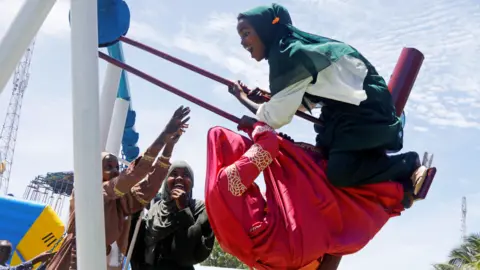 Ronald Grant Girls on a swing in Mogadishu, Somalia - Monday 2 May 2022