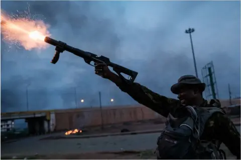 AFP A police officer firing from a gun.