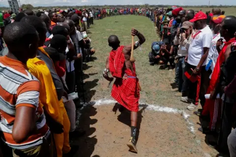Reuters A Maasai moran throws a club in a competition.
