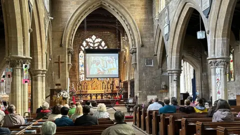 Sarah May Buccieri/BBC A big screen in St Mary's Church in Horncastle