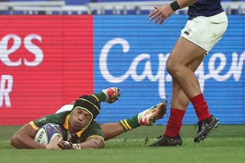 FRANCK FIFE / AFP South Africa's wing Kurt-Lee Arendse (L) dives past France's full-back Thomas Ramos to score a try during the France 2023 Rugby World Cup quarter-final match between France and South Africa at the Stade de France in Saint-Denis, on the outskirts of Paris, on October 15, 2023.