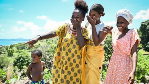 Miguel Medina/AFP Laughing girls in the Mavadzani shantytown in Mayotte, France - Friday 8 December 2023