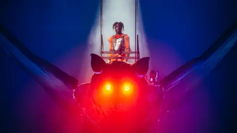 Joseph Okpako/Getty Images Rema riding a giant bat at the O2 Arena in London, UK - 14 November 2023