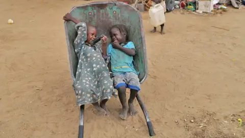 Zohra Bensemra/Reuters Two girls giggling in a wheelbarrow, Koufroun, Chad - Wednesday 10 May 2023
