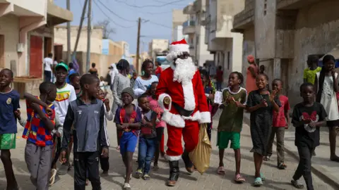 Cem Ozdel/Getty Images Thierno Gueye dresses up as Santa Claus in Dakar, Senegal - 24 December 2023