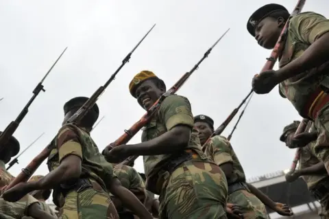 AFP A soldier of the Zimbabwe Defence Force pulls a funny face as she marches in formation during drills to prepare for the inauguration of incoming president Emerson Mnangagwa at the capital Harare's national stadium Zimbabwe's former vice president Emmerson Mnangagwa flew home on November 22 to take power after the resignation of Robert Mugabe put an end to 37 years of authoritarian rule. Mnangagwa will be sworn in as president at an inauguration ceremony on November 24.