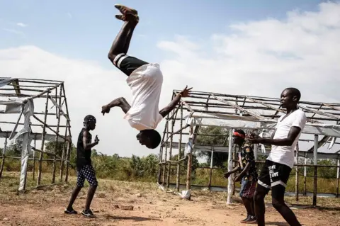 AFP Members of the South Sudanese refugee dance group "The White Family" perform during Bidibidis Got Talent auditions at Bidibidi refugee settlement in the Northern District of Yumbe, Uganda, on November 25, 2017. The Bidibidis Got Talent project has been holding auditions across the five zones of the worlds largest refugee settlement for both refugees and members of the local community to empower youth and enhance social cohesion between different ethnic groups and with Ugandan host community. The winning groups will be mentored by established Ugandan artists after the final audition on December 9.