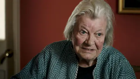 BBC/Passion Pictures Ltd/James Incledon Lynn Barber an Oxford friend of Howard Marks. She has short fair hair and is wearing a blue and black patterned jacket. 