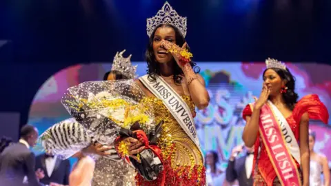 Benson Ibeabuchi / AFP Chidimma Adetshina, the winner of Miss Universe Nigeria, holding a bouquet of flowers and wearing a large crown in Lagos, Nigeria - Saturday 31 August 2024