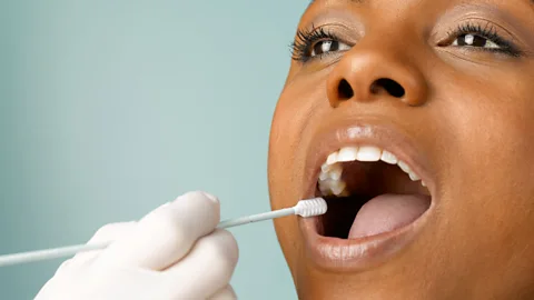 Peter Dazeley/Getty Images Person putting DNA test swab into woman's mouth (Credit: Peter Dazeley/Getty Images)