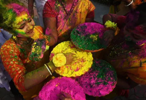 DIBYANGSHU SARKAR/ AFP Indian students play with coloured powders to celebrate Holi festival.