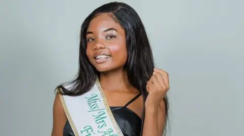 Mark Hamill Photography Shows a young woman with long black hair and a black top with a green and white sash 
